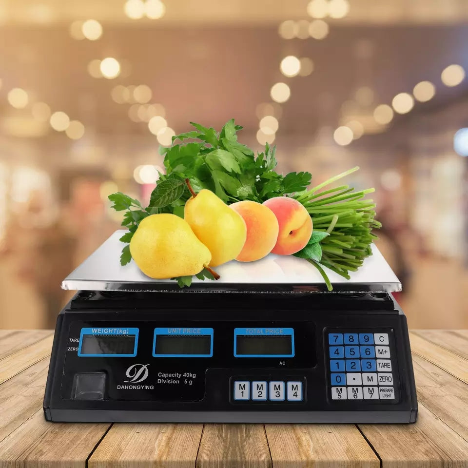 Digitalna vaga meri voce (kruske i breskve) i zeleniš na drvenom stolu sa pozadinskim svetlima.