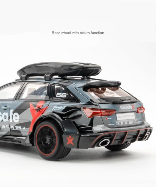 Detaljan prikaz zadnjeg dela modela srebrnog Audi RS6 Avant automobila sa "betsafe" i "Gumball 3000" oznakama. Automobil ima krovni nosac i crvene detalje oko zadnjih svetala i branika. U gornjem delu pise zadnji tocak sa povratnom funkcijom.