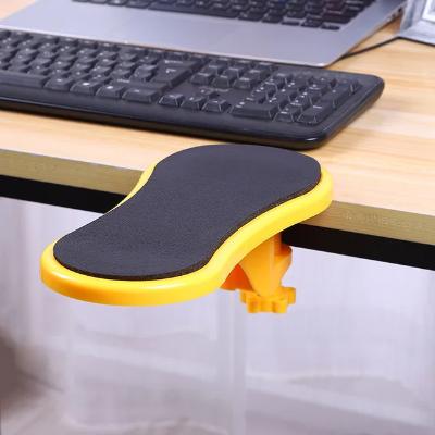 Zuti ergonomski naslon za ruku pricvrscen za sto, pruza podrsku laktu i podlaktici, poboljsava ergonomiju sedenja.