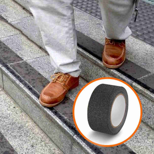 Covek se penje stepenicama sa crnom protivkliznom trakom. Sigurnost na spoljnim stepenicama uz izdrzljivu traku. Prevencija klizanja i povreda.