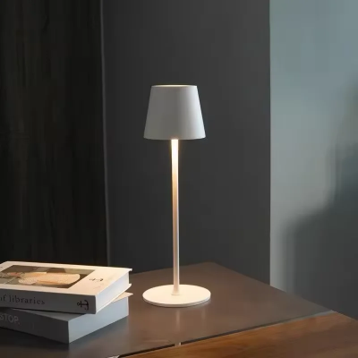 Elegantna bela stona lampa minimalisticki dizajn za nocni ormaric ili sto stvara prijatnu atmosferu idealna za spavacu sobu