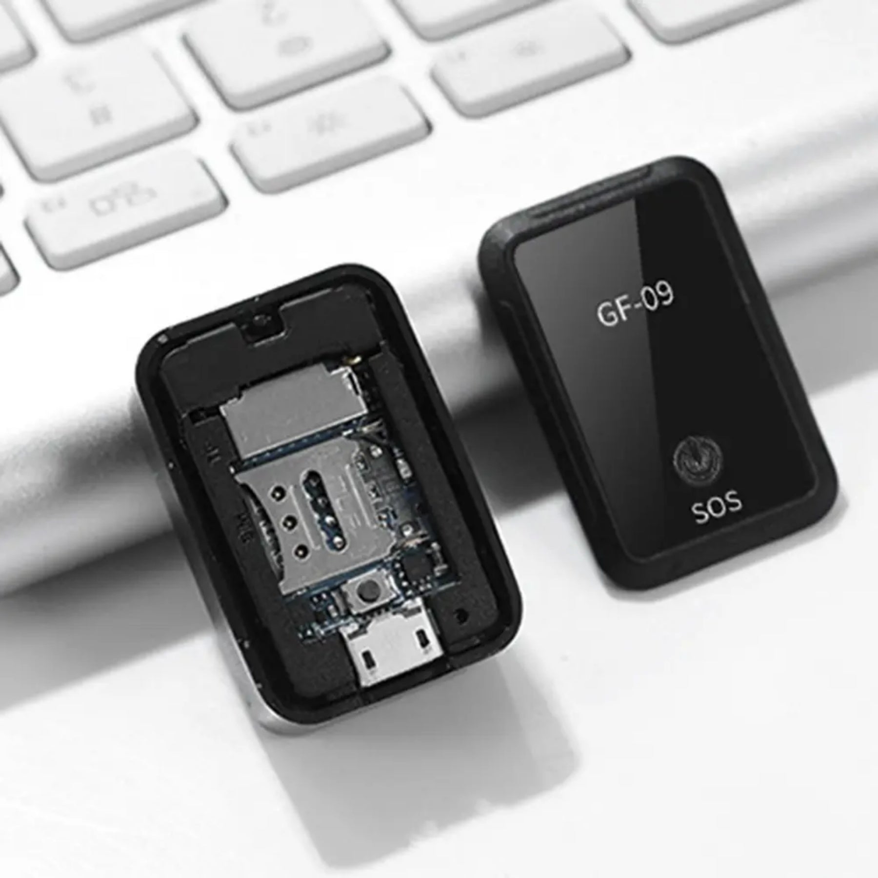Otvoren GF-09 mini GPS tracker sa vidljivim unutrasnjim komponentama i slotom za SIM karticu, pored zatvorenog trackera.