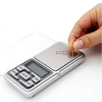 Ruka drzi digitalnu preciznu vagu. Laka za koriscenje, prenosiva i spremna za merenje.