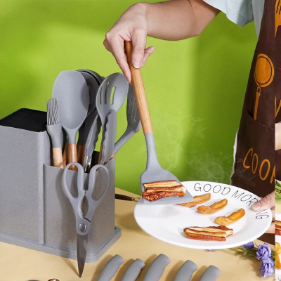 Upotreba silikonske spatule iz kuhinjskog seta sa drvenom drskom. Spatula se koristi za posluzivanje hrane sa tanjira.