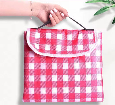 Sklopljen piknik prekrivac u roze boji. Lako se nosi kao torba, kompaktan i praktican.