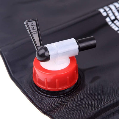 Detalj glave solarnog tusa sa ventilom za kontrolu protoka vode, prikazujuci crvenu kapicu i crevo.