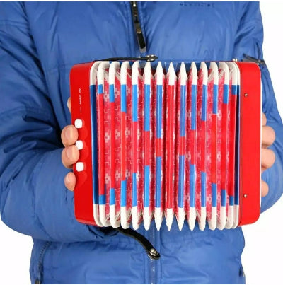 Dete se igra na decijoj harmonici igracka dugmetara crvena za ucenje muzike