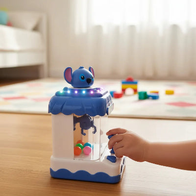 Srecno dete devojcica se igra sa mini masinom za hvatanje na stolu plava igracka Stitch razvija motoriku i vestine