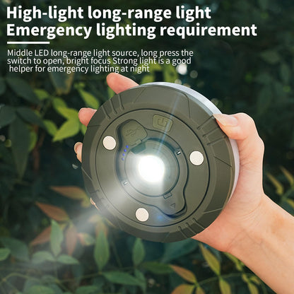 Prikaz Hplive LED lampe za kampovanje u ruci, sa upaljenim belim svetlom. Ruka drži lampu iz perspektive odozgo, sa vidljivim detaljima na površini lampe. Lampa ima zeleni okvir i crne detalje. U pozadini se vidi zelenilo, sa delimično zamućenim lišćem.