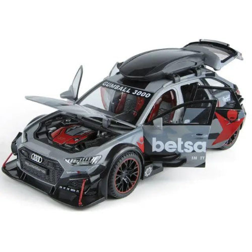Model srebrnog Audi RS6 Avant automobila sa crnim i crvenim detaljima, kao i logotipima "Gumball 3000" i "betsafe". Model ima otvorena prednja hauba, prednja i zadnja vrata, kao i prtljaznik sa krovnim nosacem. Automobil stoji na beloj pozadini.