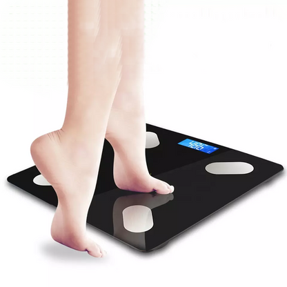 Bosa ženska stopala stoje na crnoj pametnoj vagi za telesnu analizu. Digitalni ekran vage prikazuje težinu od 48.6 kg sa plavim brojevima. Vaga ima četiri okrugla senzora od nerđajućeg čelika. Pozadina je bela.