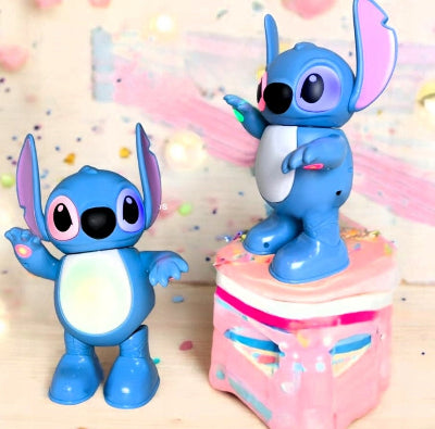 Velika figura robota Stitch plesača stoji na roze kutiji sa svetlosnim efektima deciji rodjendanski hit