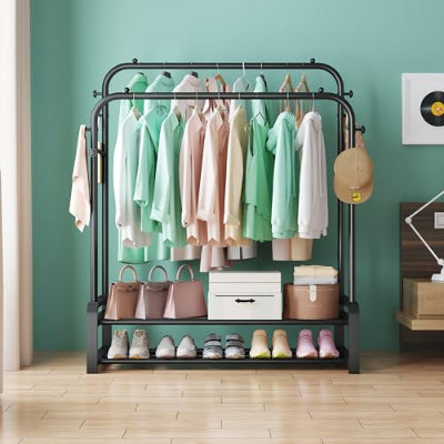 Crni metalni stalak za odecu sa raznovrsnom garderobom, obucama i torbama u uredjenoj sobi. Elegantno resenje za odlaganje.
