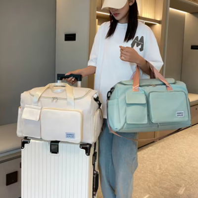 Zena nosi putnu torbu na vrhu kofera. Idealno resenje za lako nosenje prtljaga na putovanjima.