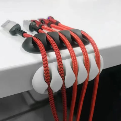 Kablovi uredno organizovani na stolu pomocu silikonskih drzaca. Resenje za cist i funkcionalan radni prostor.