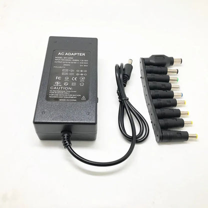 Crni adapter za laptop prikazan sa donje strane sa tekstom tehnicke specifikacije i povezanim kablom pored niza konektora