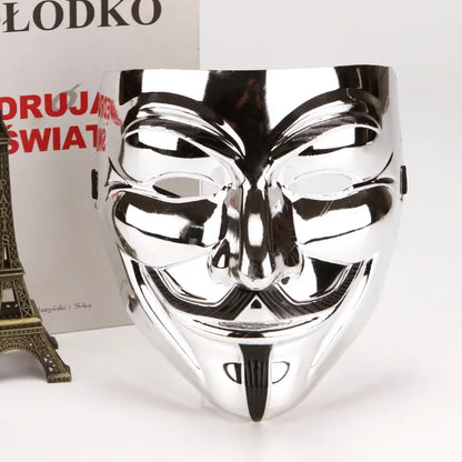 hromirana anonymous maska uspravno postavljena pored ukrasne ajfelove kule