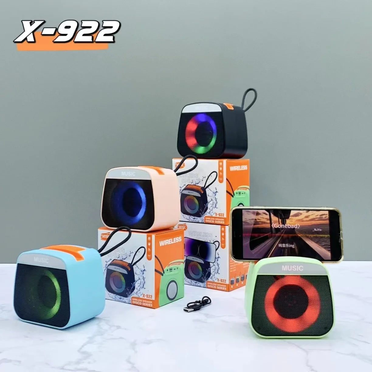 Bezicni zvucnici X-922 sa RGB osvetljenjem slozeni na kutije uz telefon