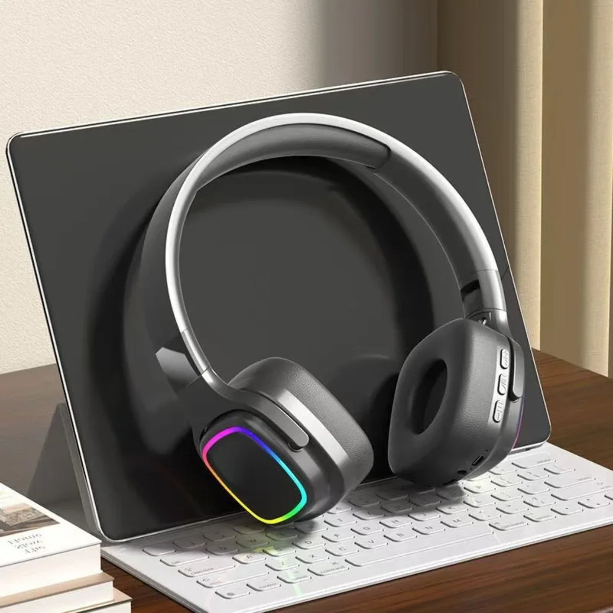 Crne RGB bezicne slusalice naslonjene na tablet iznad tastature
