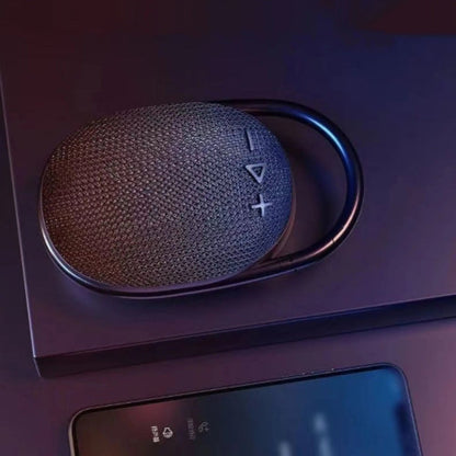 Crni bluetooth zvucnik Clip 4 na stolu pored telefona