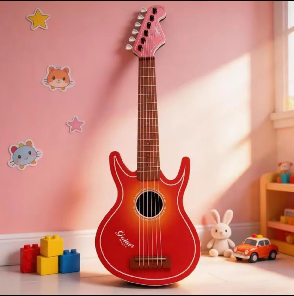 Crvena decija drvena gitara igracka naslonjena na zid u decijoj sobi