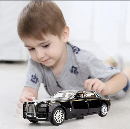 Decak se igra sa modelom automobila Rolls Royce. Igracka za decu, ljubitelje luksuznih vozila.