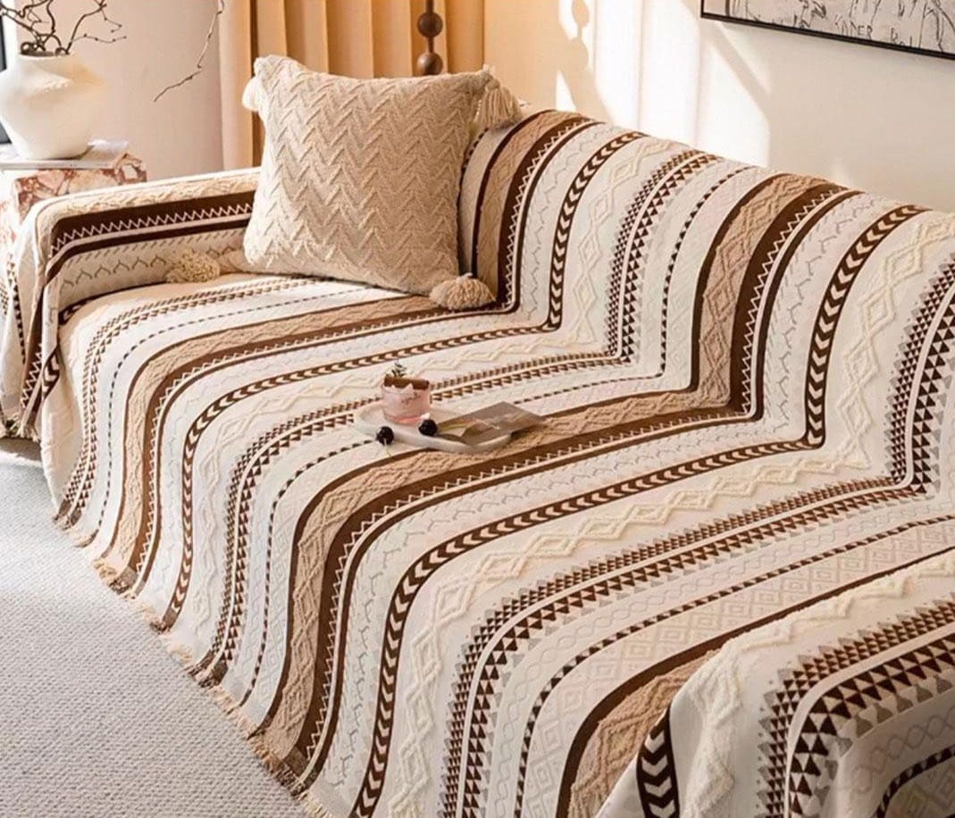 Dekorativni boho prekrivac postavljen preko kreveta u minimalistickoj sobi