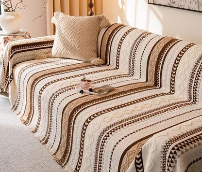 Dekorativni boho prekrivac postavljen preko kreveta u minimalistickoj sobi