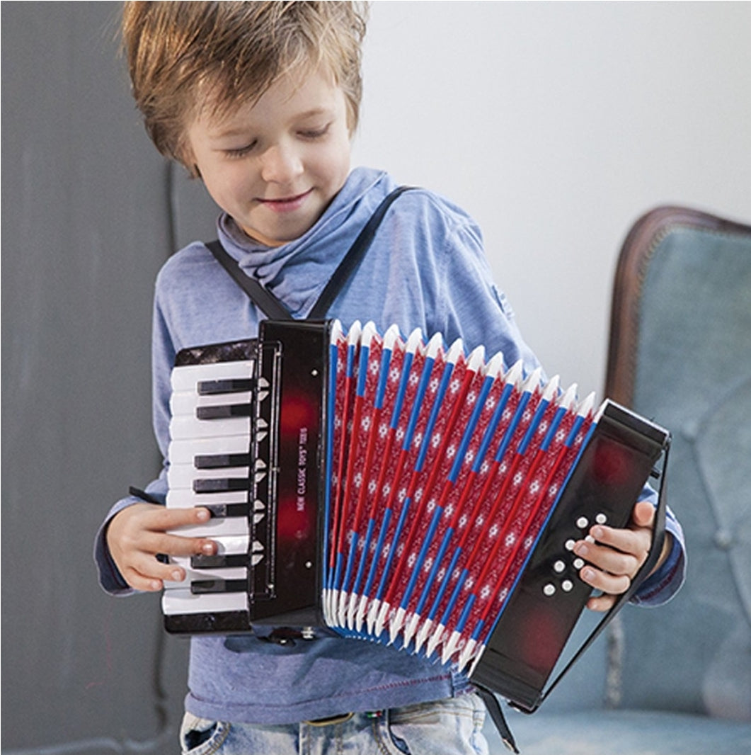 Dete stoji i svira sarenu deciju harmoniku