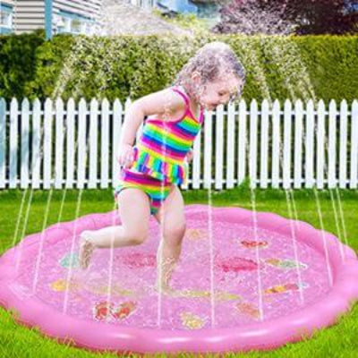 Devojcica se igra na splash padu. Zabavno osvezenje i igra na vodi za decu tokom letnjih meseci u dvoristu.