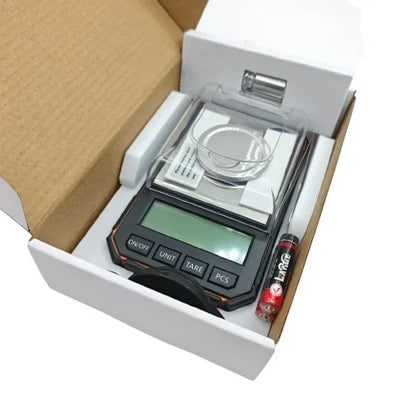 Digitalna precizna vaga u otvorenoj kutiji sa kalibracionim tegom i baterijom