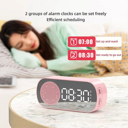 Roze digitalni budilnik sa zvucnikom na nocnom ormaricu pored kreveta