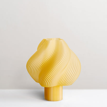 Dizajnerska stolna lampa spiralnog oblika u zutoj boji za moderan enterijer