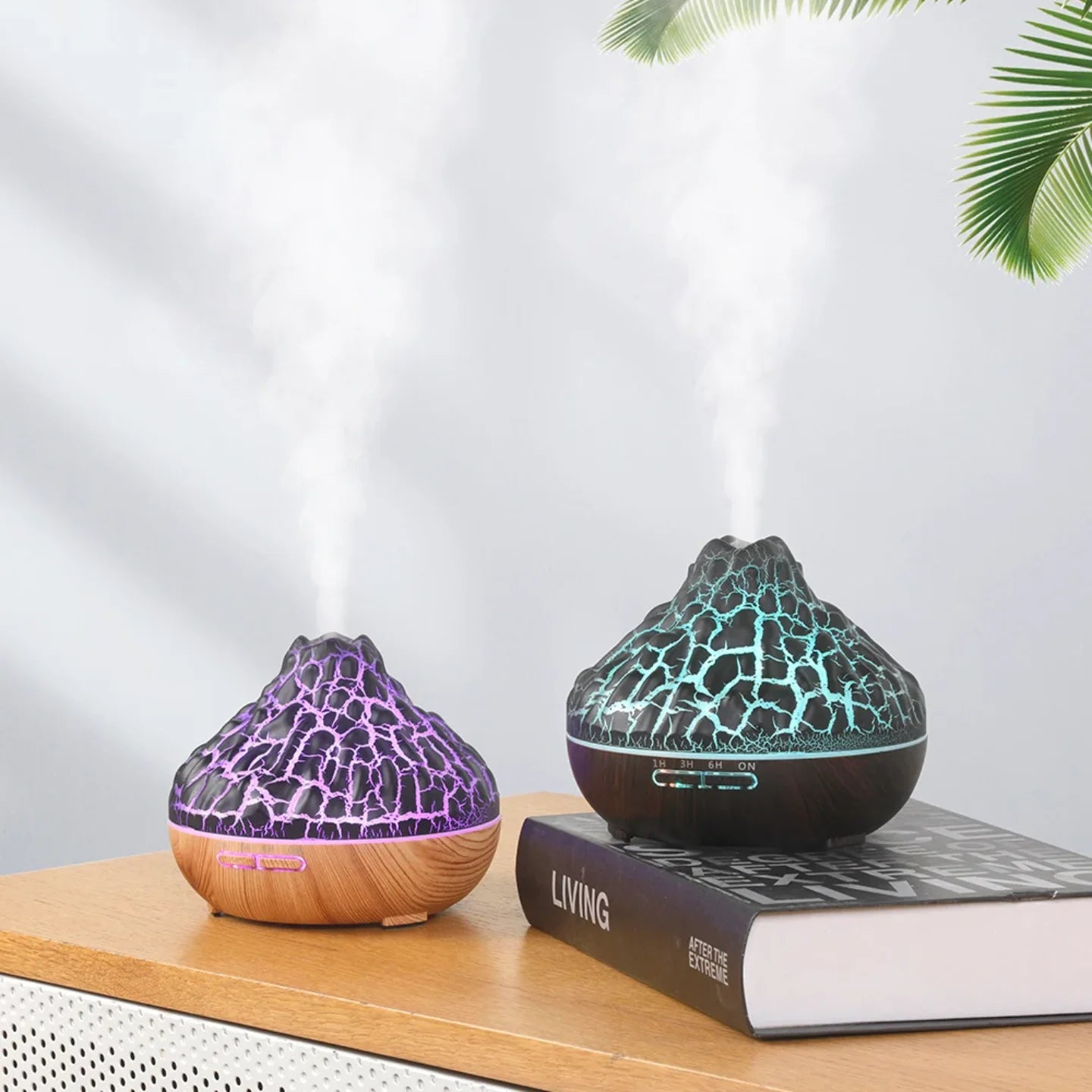 Dva vulkanska aroma difuzora sa razlicitim LED bojama na komodi