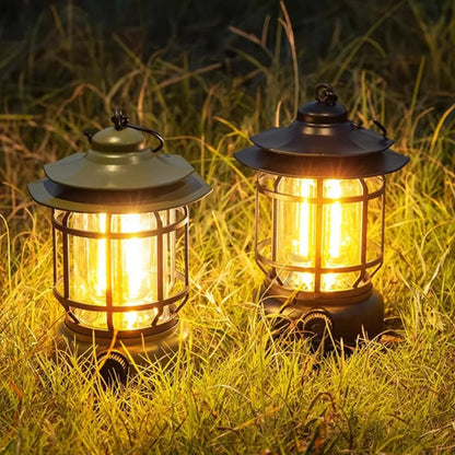 Dve retro kamperske lampe u travi nocu