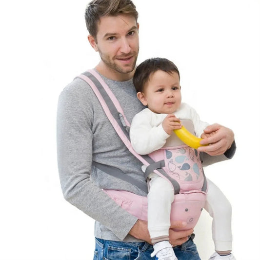 Otac nosi bebu u roze ergonomskoj nosiljci sa sedistem