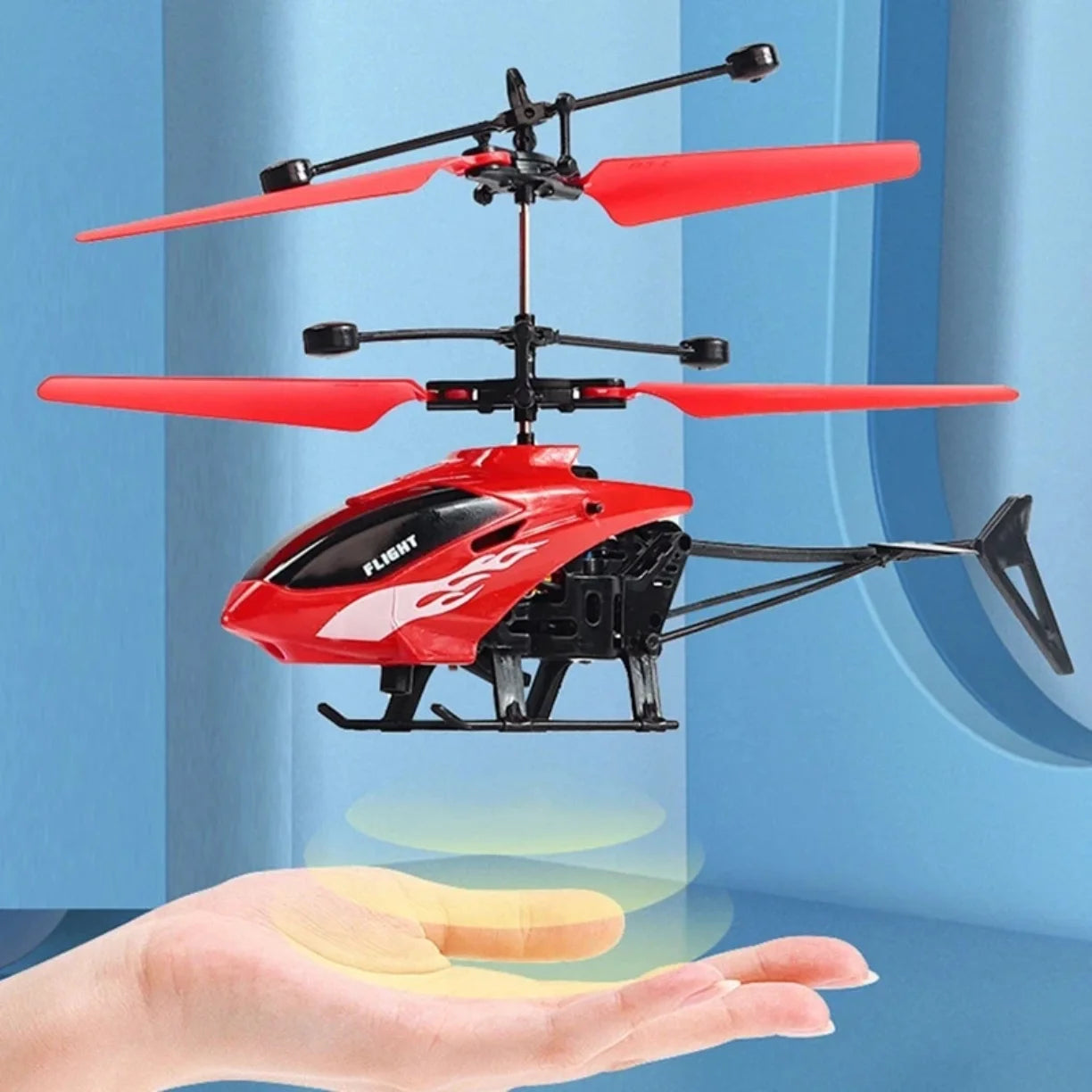 Crveni helikopter na indukciju koji lebdi iznad dlana