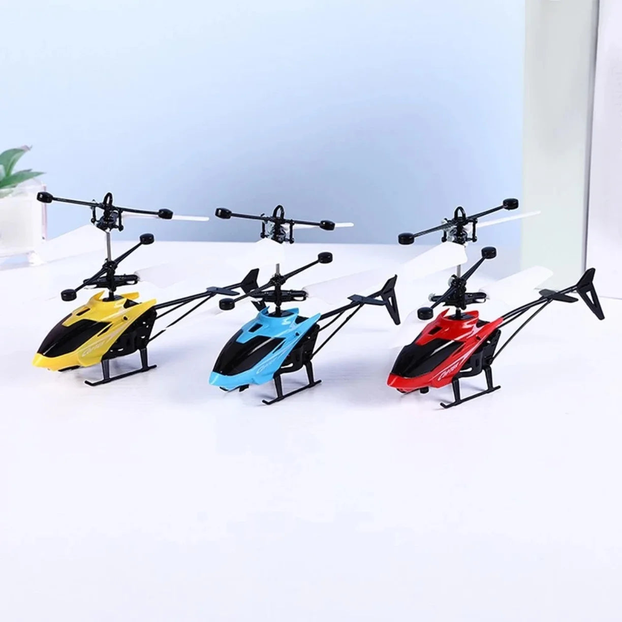 Tri helikoptera igracke na indukciju u zutoj plavoj i crvenoj boji