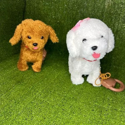 Dva interaktivna plisana psa, beli i braon, sa povocima na zelenoj podlozi. Igracke koje laju i hodaju, odlicne za igru u kuci ili dvoristu za svu decu.