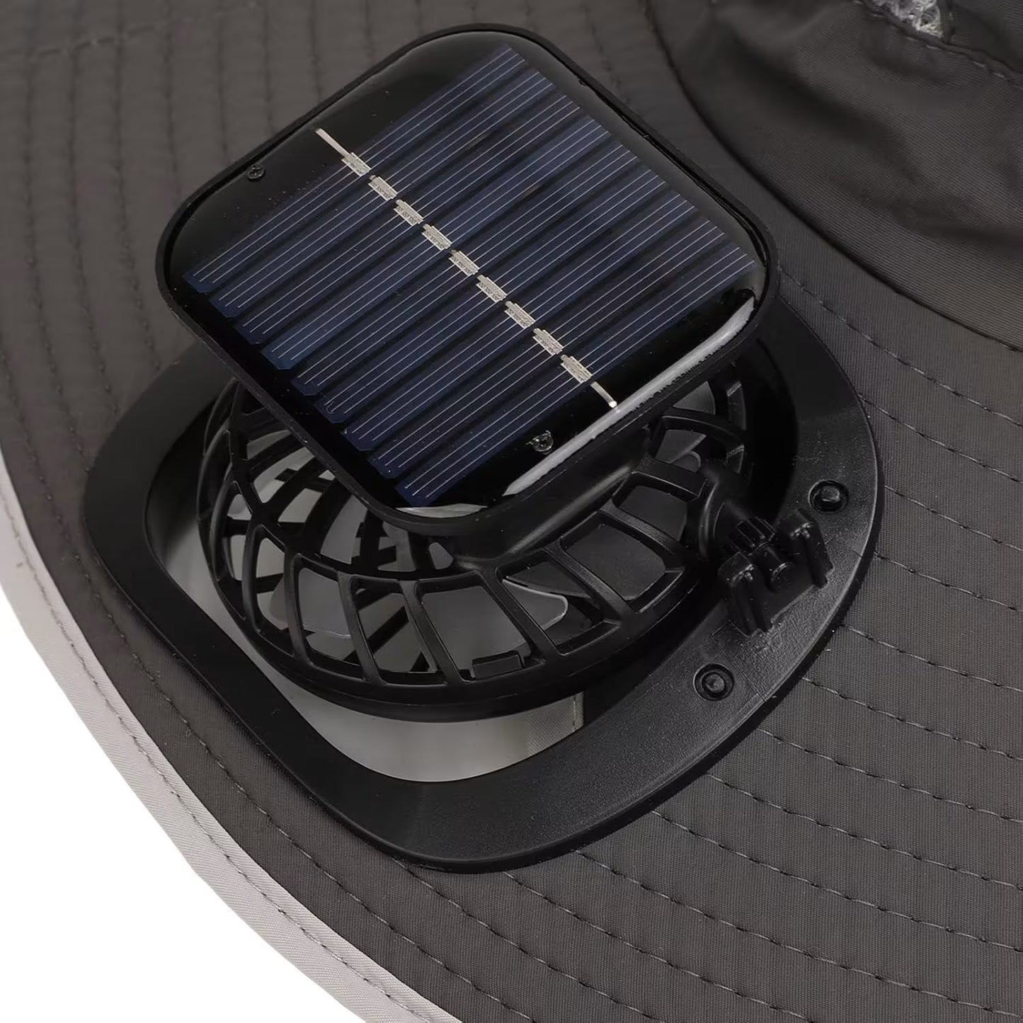 Bliski prikaz malog ventilatora i kvadratne solarne celije na kruzno prosivenom obodu sesira