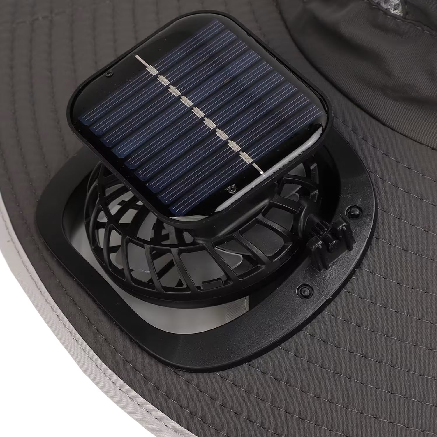 Bliski prikaz malog ventilatora i kvadratne solarne celije na kruzno prosivenom obodu sesira