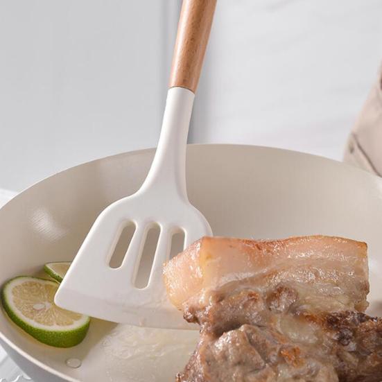 Okretanje mesa silikonskom spatulom u tiganju