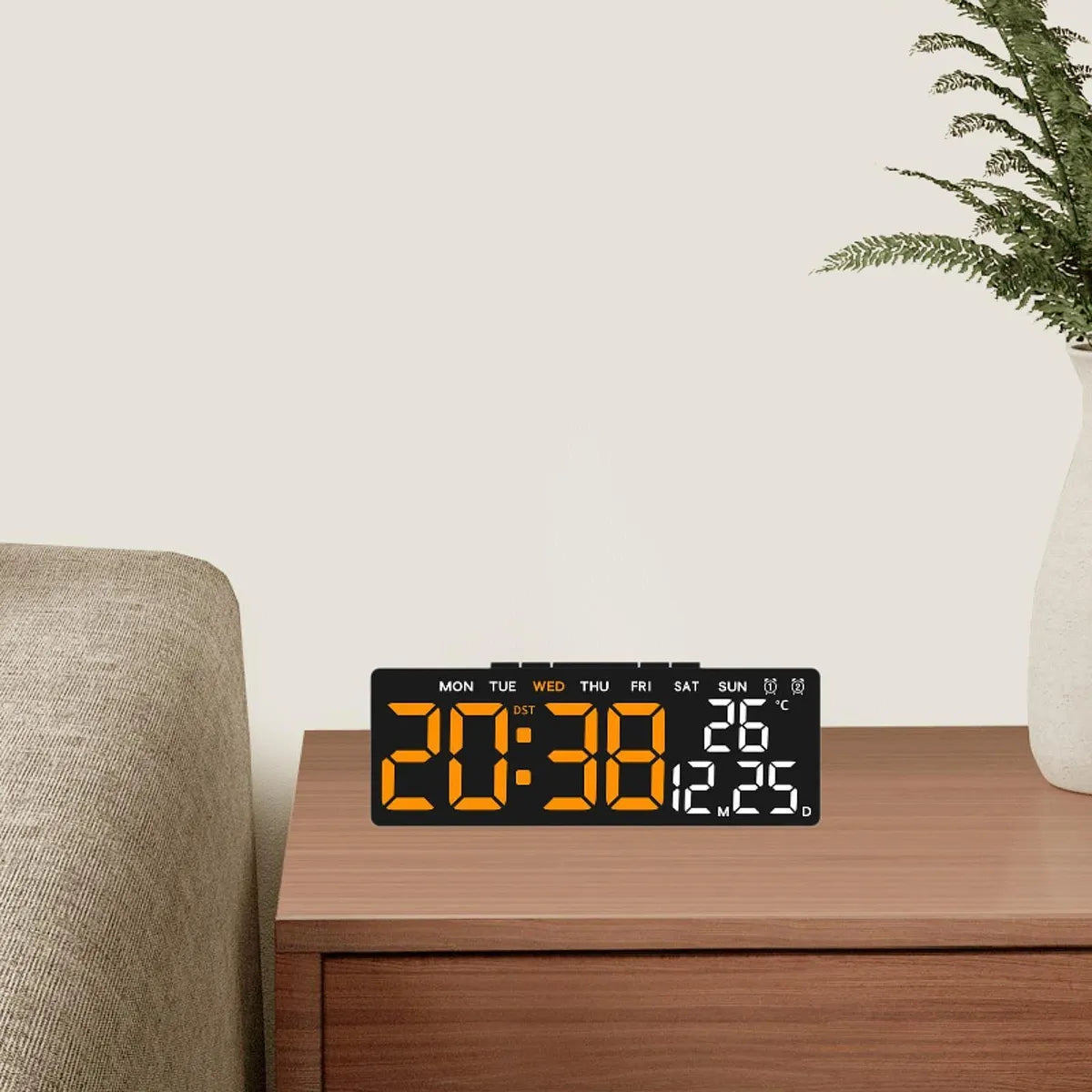 LED digitalni sat sa velikim narandžastim displejom postavljen na komodi u dnevnoj sobi