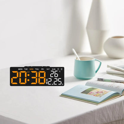 Digitalni LED sat sa velikim brojevima na stolu pored knjige i šolje