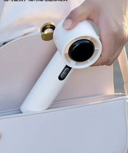 Zenska ruka koja lako pakuje kompaktan beli rucni ventilator u malu belu koznu torbicu kao dokaz prakticnosti za nosenje