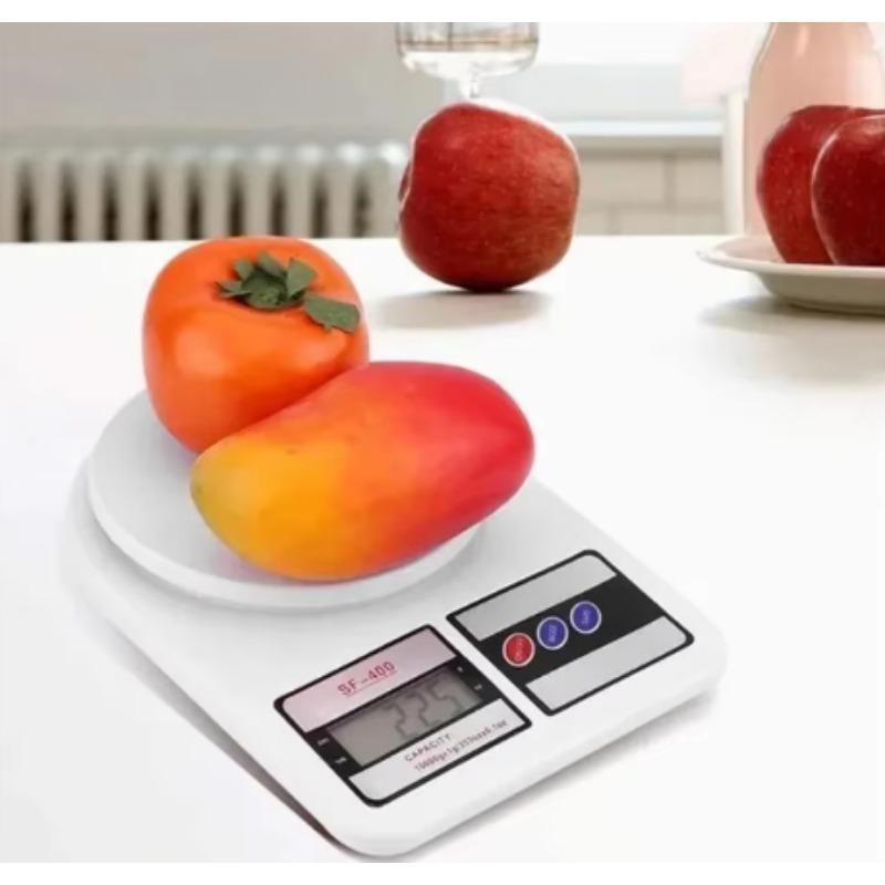 Merenje svezeg voca poput jabuke i manga na okrugloj povrsini vage