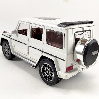 Pogled na zadnji deo belog metalnog modela G Wagona. Uocljiva je rezervna guma na gepeku, detaljna izrada zadnjih svetala i prozor retrovizora.