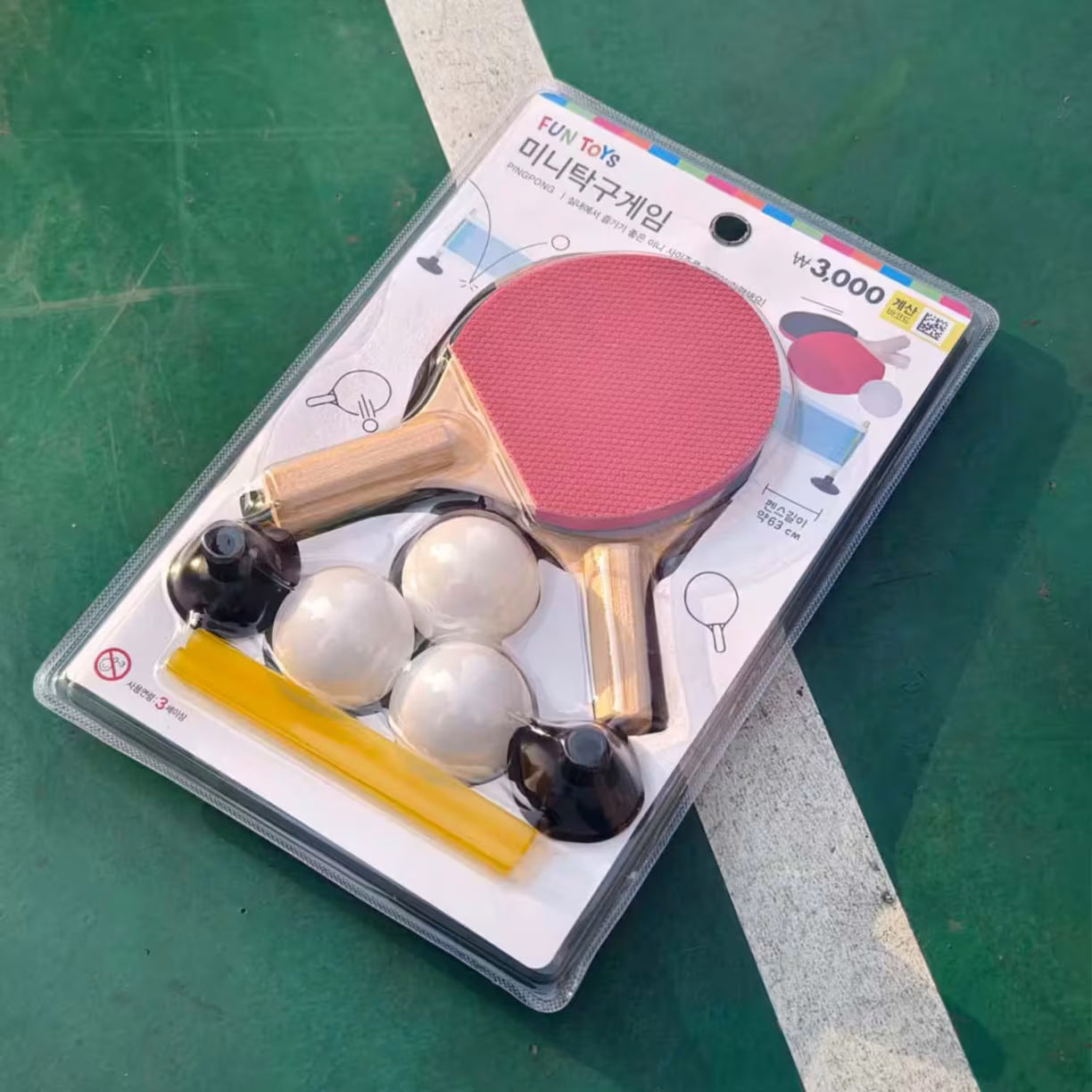 Mini stoni tenis set u originalnom blister pakovanju na zelenoj podlozi