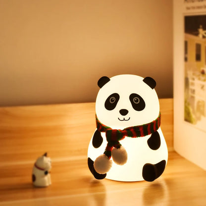 Panda nocna lampa na drvenom stolu pored knjige