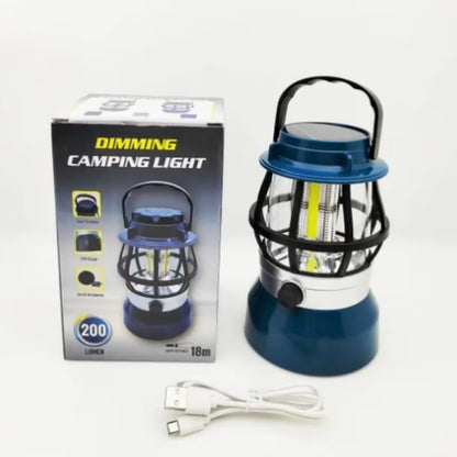Komplet koji sadrzi plavu lampu za kampovanje sa rucicom, originalnu tamnu kutiju sa oznakom jacine i beli usb kabel